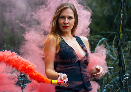 девушка в сексуальном образе с красным цветным дымом